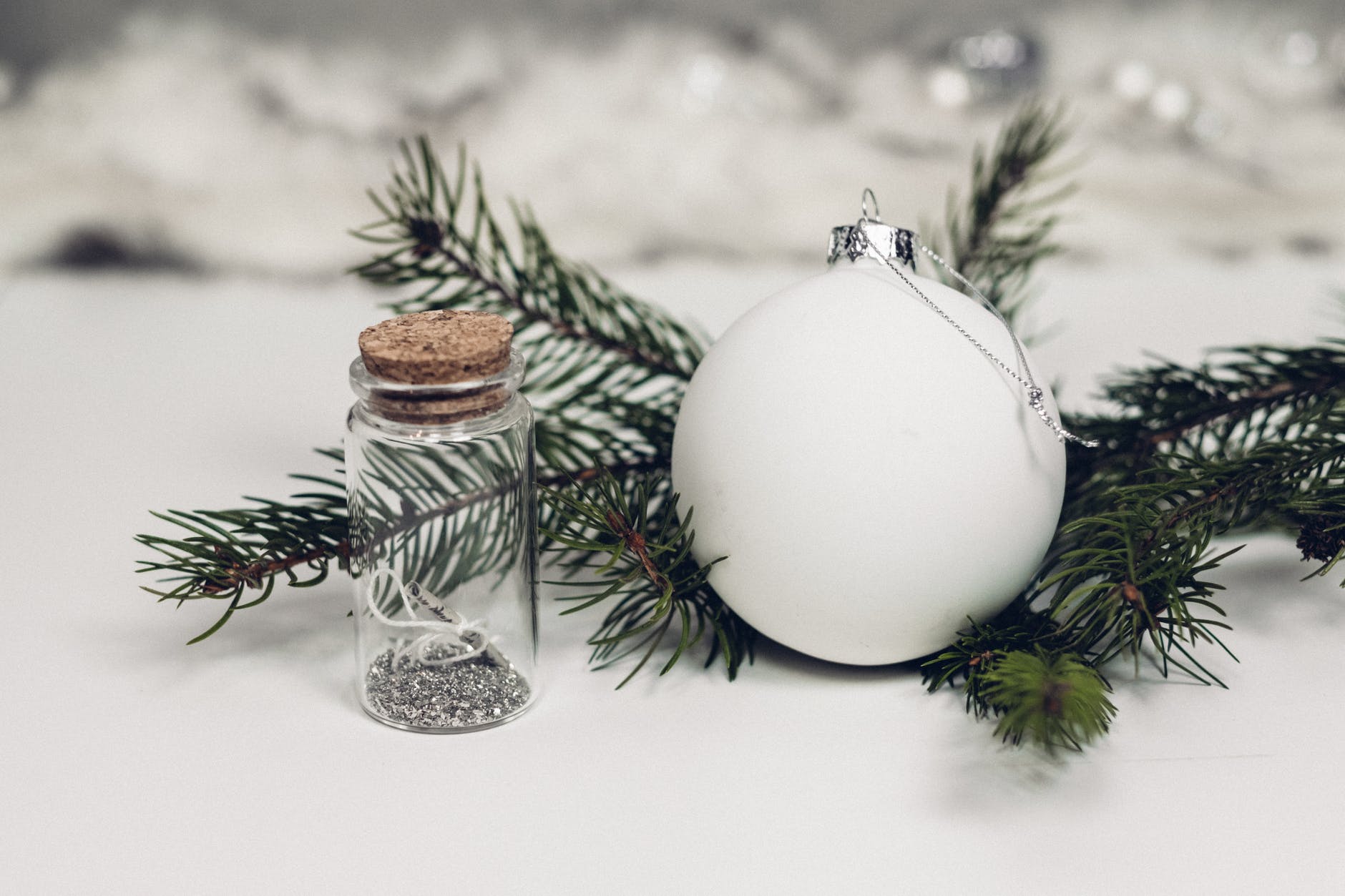 selective focus photography of white christmas bauble beside bottle with cork lid